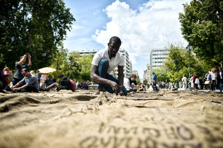 Ghanian artist Ibrahim Mahama performs "Check Point - Prosfygika" on the main Syntagma square in Athens on April 7, 2017 on the eve of the opening of the 14th edition of the Documenta 14 art exhibition