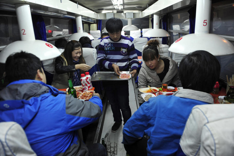 A waiter serves customers inside a coach restaurant in Shenyang