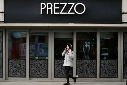 FILE PHOTO: A woman walks past a Prezzo restaurant in London, Britain March 23, 2018. 2018. REUTERS/Hannah McKay