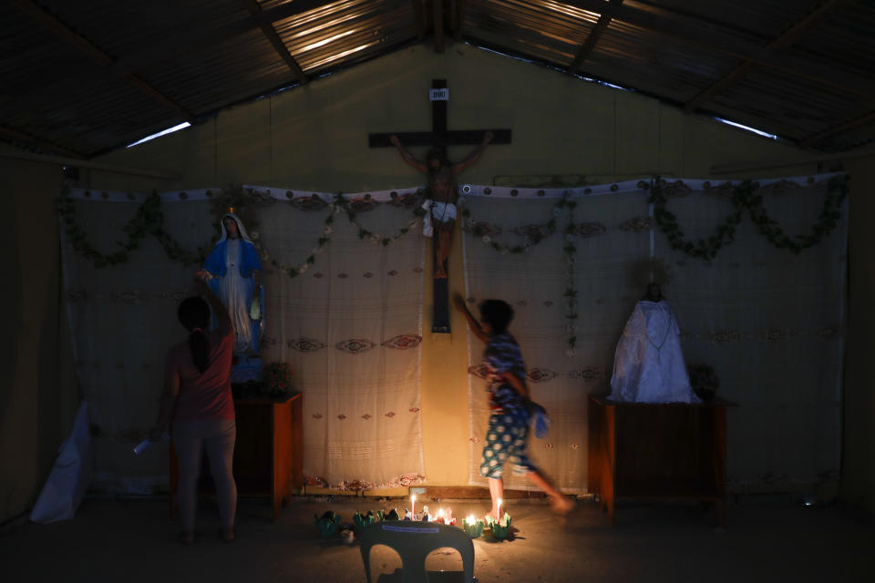 Residents who used to live at Taal volcano pray at their chapel at a relocation site in Balete, Batangas province, Philippines, Sunday, Jan. 10, 2021. Some families are still living in tents and have resorted to taking odd jobs to make a living as the government has prevented them from returning back to their homes almost a year after Taal volcano erupted. Taal erupted on Jan. 12, 2020. The eruption displaced thousands of villagers living near the area and delivered an early crisis this year for one of the world's most disaster-prone nations a couple of months before the COVID-19 pandemic broke in the country. (AP Photo/Aaron Favila)