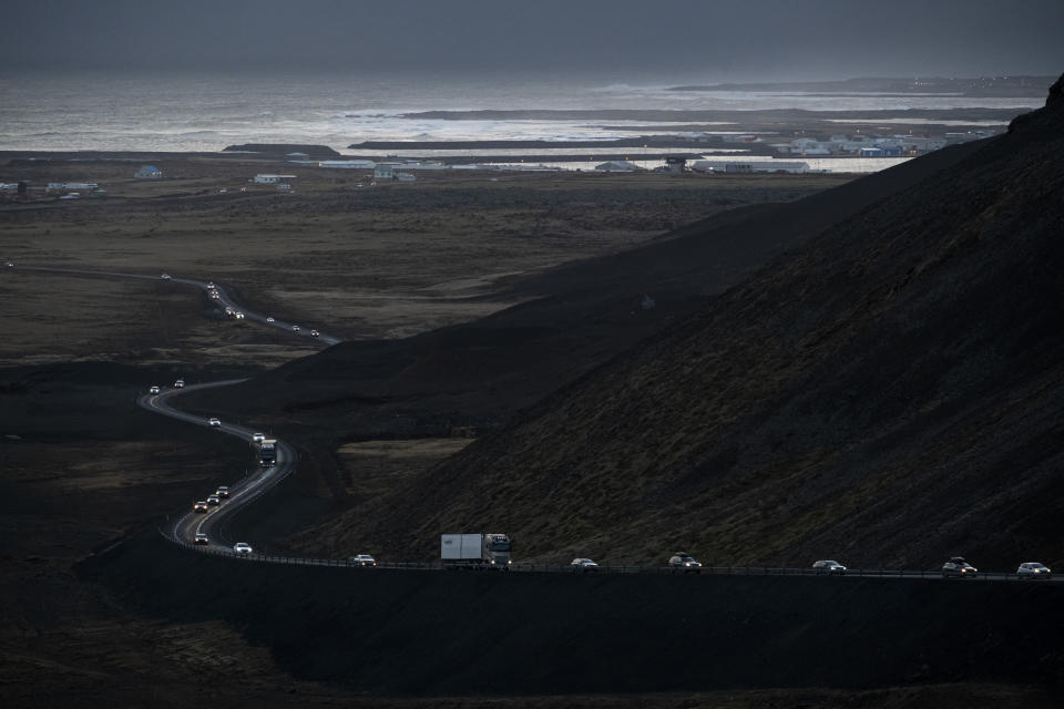 vehicles leaving the town of Grindavik, southwestern Iceland, during evacuation following earthquakes., with the sea in the background