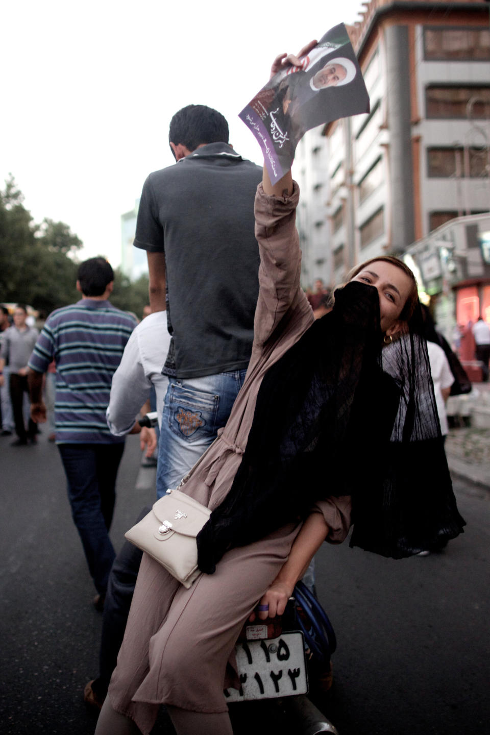 An Iranian woman holds a portrait of moderate presidential candidate Hassan Rouhani as she rides on a motorcycle along Valiasr street in Tehran on June 15, 2013 after he was elected as president. (BEHROUZ MEHRI/AFP/Getty Images)