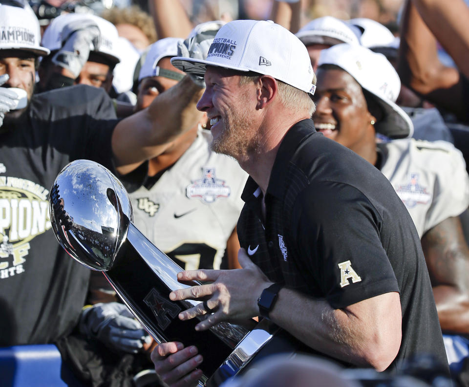 Central Florida head coach Scott Frost holds the winning trophy after defeating Memphis in the American Athletic Conference championship. (AP Photo/John Raoux)