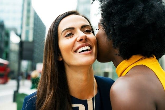 A woman kissing another woman on the cheek