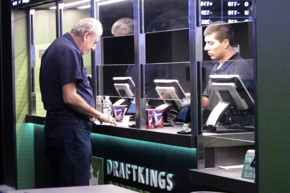 A man places a sports bet at a DraftKings sportsbook in Atlantic City, New Jersey, on Oct. 8, 2019. New Jersey regulators have fined DraftKings $100,000 on June 17, 2024, for reporting inaccurate sports betting data to the state and will require the company to correct and republish New Jersey sports betting data for December 2023 and January and February 2024. (Photo by The Associated Press/Wayne Parry)