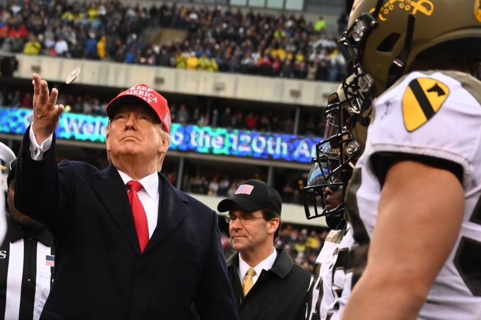 President Donald Trump tosses the coin before the Army-Navy game in December.