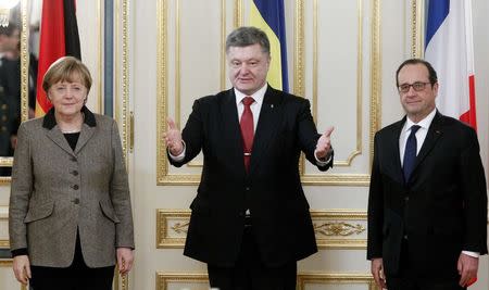 Ukraine's President Petro Poroshenko (C) gestures to German Chancellor Angela Merkel and French President Francois Hollande during their talks in Kiev, February 5, 2015. REUTERS/Valentyn Ogirenko