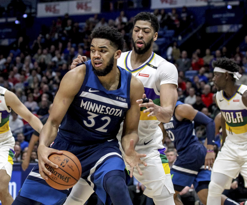 Minnesota Timberwolves center Karl-Anthony Towns (32) works against New Orleans Pelicans forward Anthony Davis during the first half of an NBA basketball game in New Orleans, Friday, Feb. 8, 2019. (AP Photo/Scott Threlkeld)