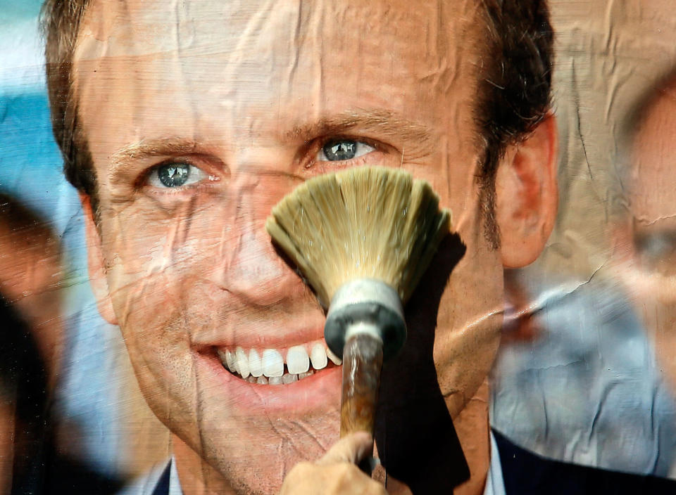 <p>A supporter of French centrist presidential candidate Emmanuel Macron glues a campaign poster, in Saint-Jean-de-Luz, southwestern France, Thursday, April 27, 2017. After “the battle of Whirlpool,” when Marine Le Pen and Emmanuel Macron both went hunting for France’s blue-collar vote at a threatened home appliance factory, the presidential candidates clashed over fish in a return to more traditional campaigning on Thursday. (AP Photo/Bob Edme) </p>