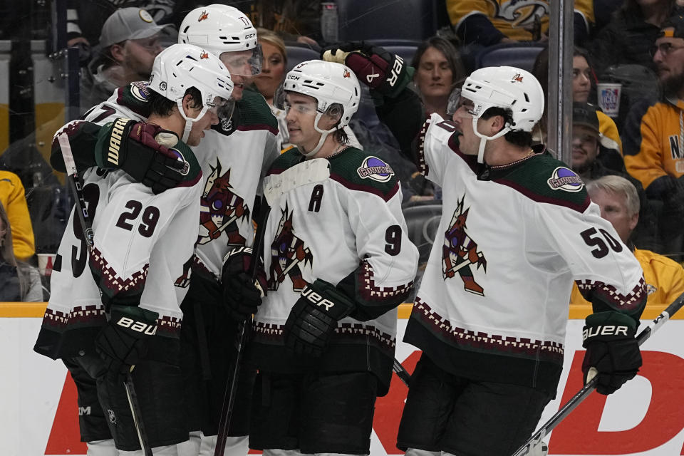 Arizona Coyotes center Nick Bjugstad, second from left, is congratulated by teammates center Barrett Hayton (29), right wing Clayton Keller (9) and defenseman Sean Durzi (50) after an empty net goal against the Nashville Predators during the third period of an NHL hockey game Saturday, Nov. 11, 2023, in Nashville, Tenn. The Coyotes won 7-5. (AP Photo/George Walker IV)