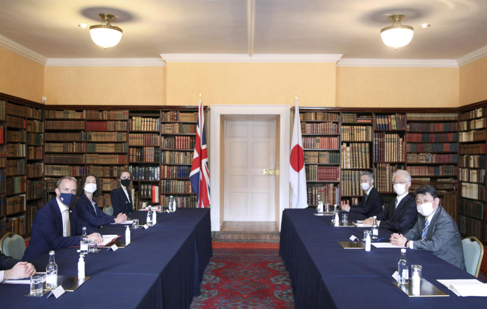 Britain's Foreign Secretary Dominic Raab, left, meets with Japan's Foreign Minister Toshimitsu Motegi, right, accompanied by aides, during their talks in Kent, southern England, Monday May 3, 2021. (Tom Nicholson/Pool via AP)