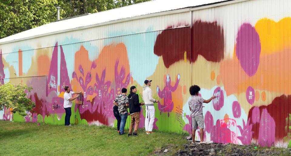 FILE PHOTO - Volunteers paint a mural on the side of a public works building on Iverson Street in Poulsbo in 2018.