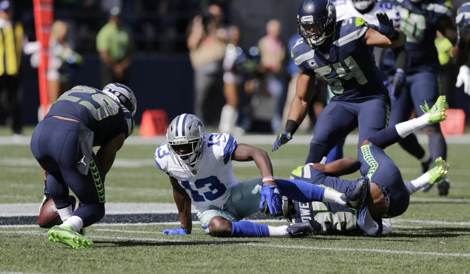 Seattle Seahawks free safety Earl Thomas, left, intercepts a pass intended for Dallas Cowboys wide receiver Michael Gallup (13) during the first half of an NFL football game, Sunday, Sept. 23, 2018, in Seattle. (AP Photo/John Froschauer)