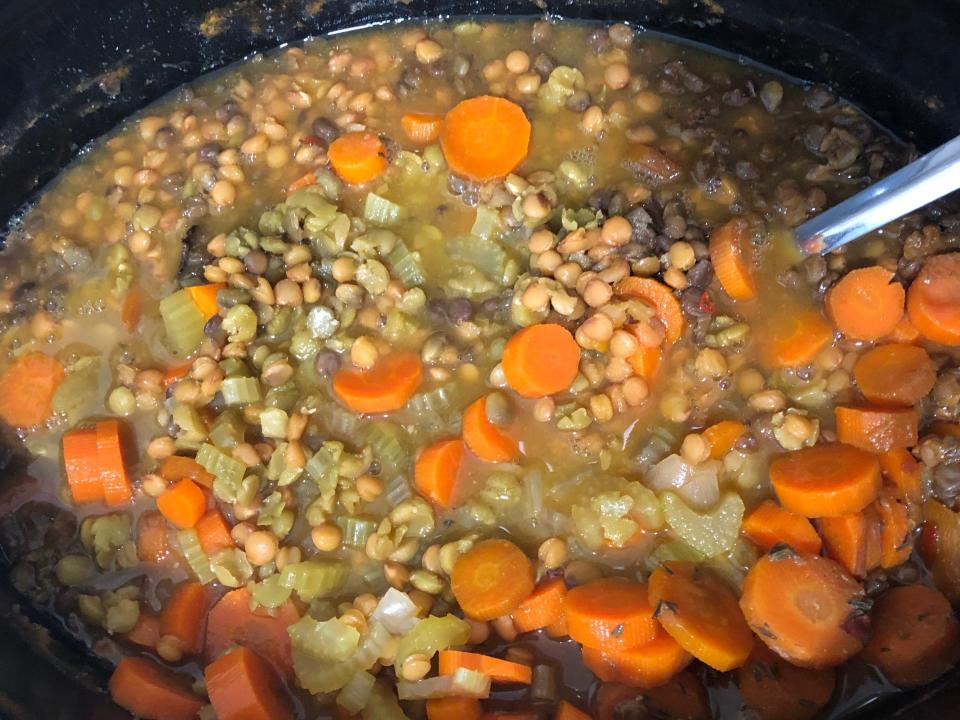 A ladle in a Crock-Pot filled with split-pea and lentil soup.