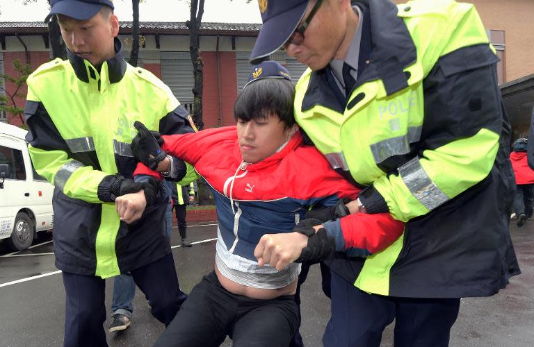 Policemen remove a pro-Taiwan independence activist from Parliament during a protest in Taipei on March 27, 2015