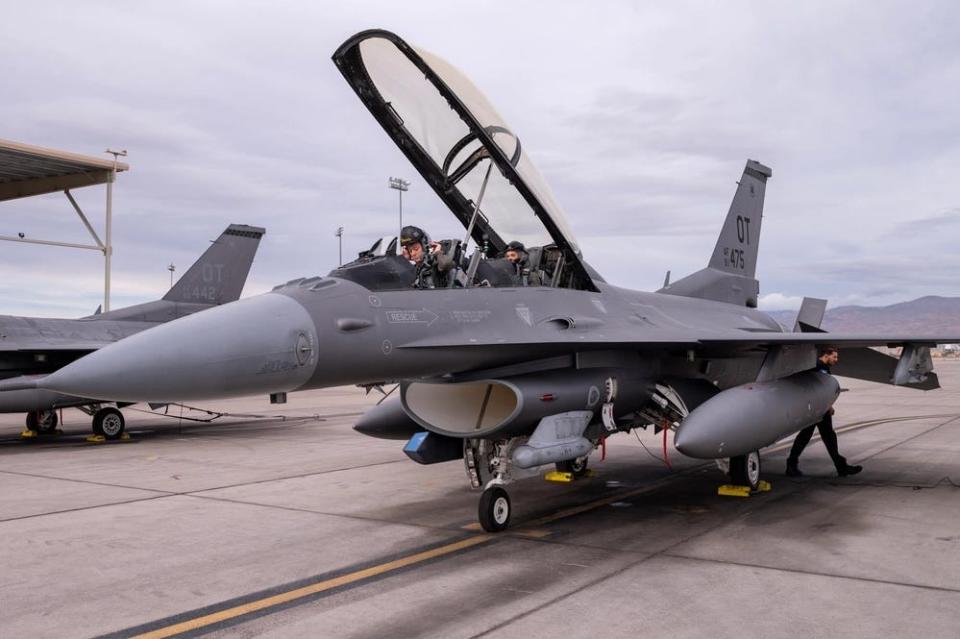 two people sit in the cockpit of an aircraft with the top open