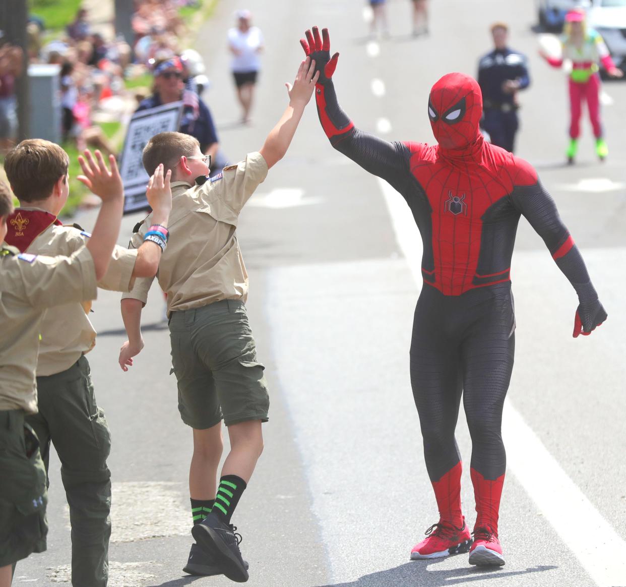Spider Man high fives kids along the 64th annual Stow Parade on Tuesday, July 4, 2023 in Stow.