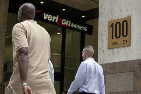 People pass by a Verizon store at 100 Wall St. in New York's financial district May 12, 2015. REUTERS/Brendan McDermid