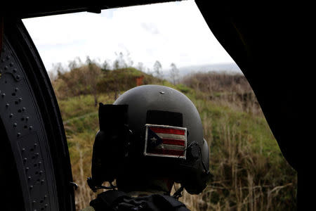 Sergeant First Class Eladio Tirado, who is from Puerto Rico, looks for a landing spot for a UH-60 Blackhawk helicopter from the First Armored Division's Combat Aviation Brigade, during recovery efforts following Hurricane Maria near Ciales, Puerto Rico, October 7, 2017. REUTERS/Lucas Jackson