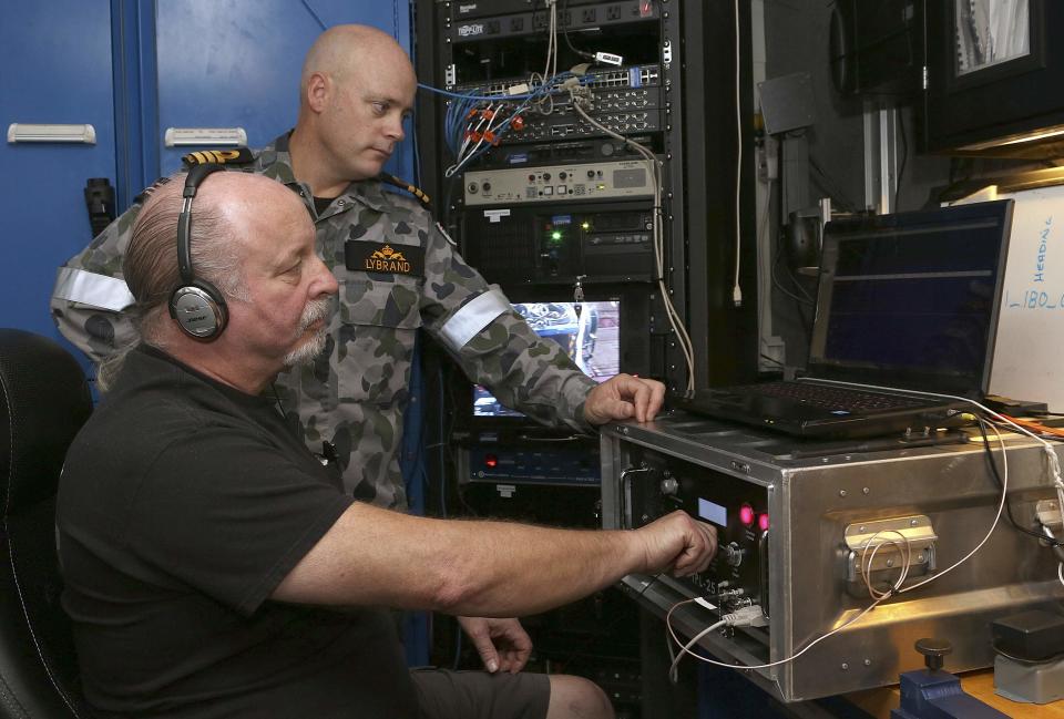 Royal Australian Navy Commander James Lybrand (R), the Mission Commander of the Australian Defence Vessel Ocean Shield, watches as Mike Unzicker from Phoenix International monitors the feed from the towed pinger locator in the southern Indian Ocean during the continuing search for the missing Malaysian Airlines flight MH370 in this picture released by the Australian Defence Force April 7, 2014. Australian officials said on Monday signals picked up by a black box detector attached to an Australian ship searching for MH370 were consistent with aircraft flight recorders. Confirmation of whether the signals were emitted from the Kuala Lumpur-to-Beijing bound plane, missing since March 8 with 239 people on board, could take several days, according to Angus Houston, head of the Australian agency coordinating the search. REUTERS/Australian Defence Force/Handout via Reuters (MID-SEA - Tags: MILITARY TRANSPORT DISASTER MARITIME TPX IMAGES OF THE DAY) ATTENTION EDITORS - THIS PICTURE WAS PROVIDED BY A THIRD PARTY. REUTERS IS UNABLE TO INDEPENDENTLY VERIFY THE AUTHENTICITY, CONTENT, LOCATION OR DATE OF THIS IMAGE. THIS PICTURE IS DISTRIBUTED EXACTLY AS RECEIVED BY REUTERS, AS A SERVICE TO CLIENTS. NO SALES. NO ARCHIVES. FOR EDITORIAL USE ONLY. NOT FOR SALE FOR MARKETING OR ADVERTISING CAMPAIGNS
