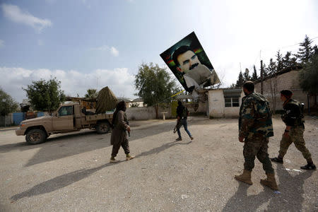 Turkish-backed Free Syrian Army fighters remove a picture of Kurdistan Workers Party (PKK) leader Abdullah Ocalan in Kafr Jana village north of Afrin, March 7. REUTERS/Khalil Ashawi