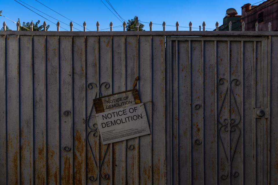 Blanca Ruiz lives behind the gate on South Figueroa Street with the demolition notice posted in Los Angeles.