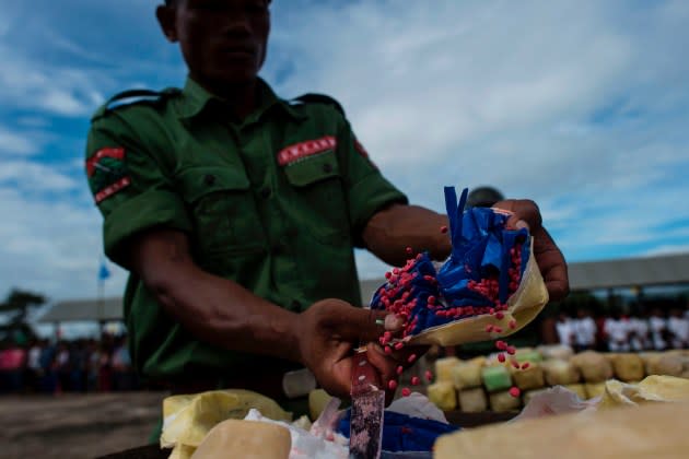 Members of UWSA (United Wa State Army) empty a packet of "WY," also know as Ya Ba drug, before they are set on fire during a drug-burning ceremony to mark the U.N.'s world anti-drugs day in Poung Par Khem, near the Thai and Myanmar border on June 26, 2017. - Credit: Ye Aung Thu/AFP/Getty Images