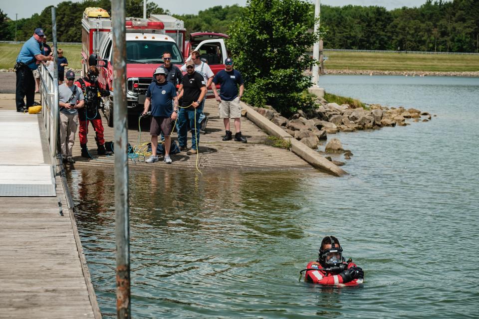 Joey Clark of the Dover Fire Department dive team swims to a sunken jon boat June 10 at the Atwood Lake boat launch in Warren Township. Personnel from the Dover Fire Department, Bowerston Volunteer Fire Department and rangers from the Muskingum Watershed Conservancy District participated in the recovery.