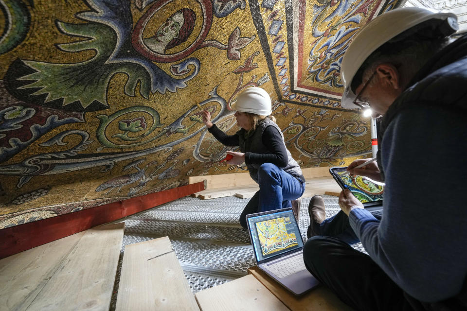 Restorers Chiara Zizola, right, and Roberto Nardi work at the restoration of the mosaics that adorn the dome of one of the oldest churches in Florence, St. John's Baptistery, in Florence, central Italy, Feb. 7, 2023. The restoration work will be done from an innovative scaffolding shaped like a giant mushroom that will stand for the next six years in the center of the church, and that will be open to visitors allowing them for the first and perhaps only time, to come come face to face with more than 1,000 square meters of precious mosaics covering the dome. (AP Photo/Andrew Medichini)