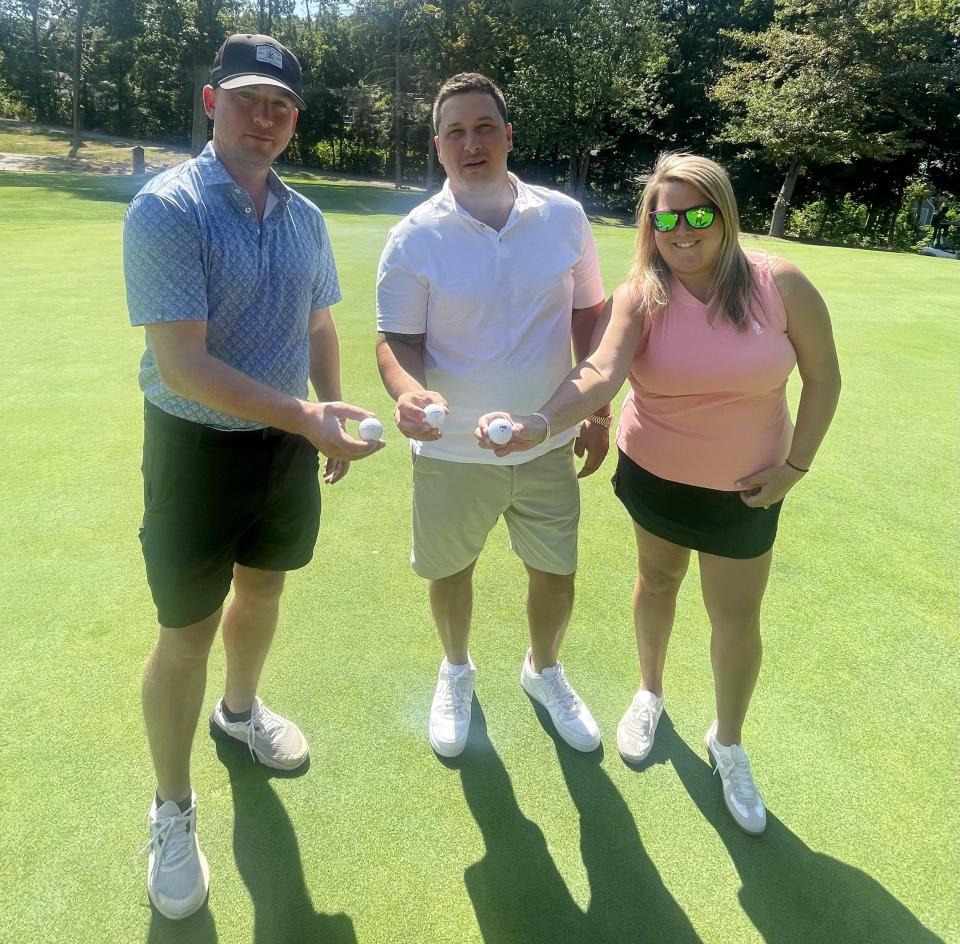 From left, Patrick Hanlon, Greg Jouki and Lauren Birkbeck stand on the fifth green and show the golf balls they used to card holes in one on the par-4 hole at Tatnuck CC.