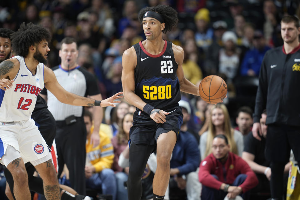 Denver Nuggets forward Zeke Nnaji (22) looks to pass the ball as Detroit Pistons forward Isaiah Livers (12) defends in the second half of an NBA basketball game Sunday, Jan. 7, 2024, in Denver. (AP Photo/David Zalubowski)