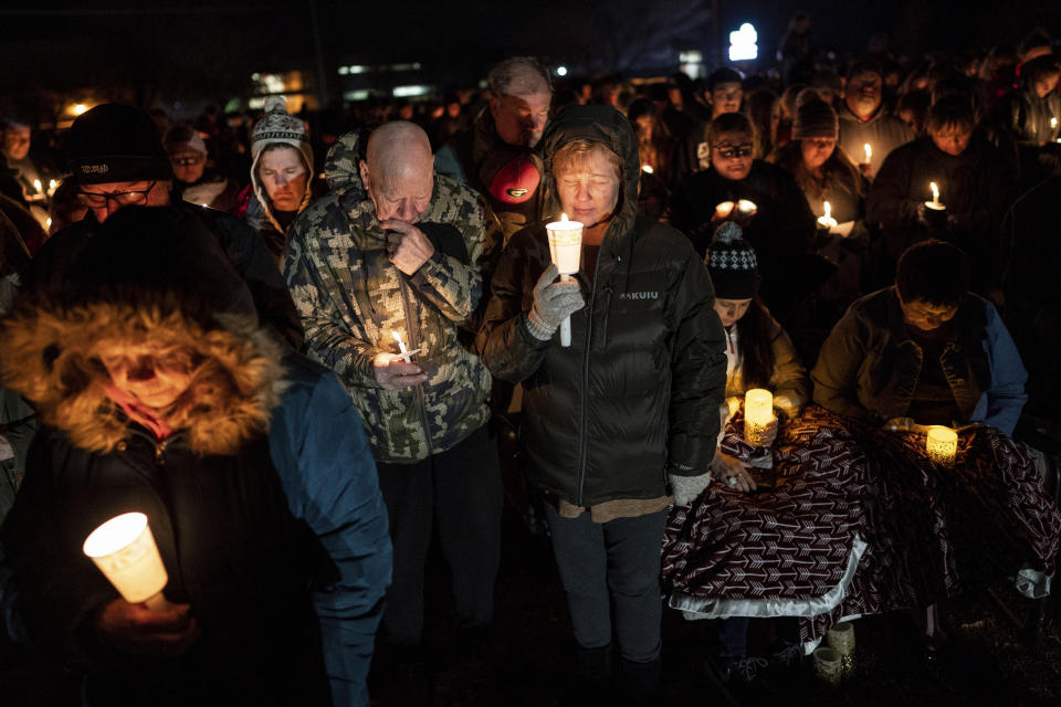 Jack and Holly Nelson, center, join others in prayer during a candlelight vigil for the Haynie family at City Park in Grantsville, Utah, Monday, Jan. 20, 2020. Police say four members of the Haynie family were killed and one injured after being shot by a teenage family member on Jan. 17. (Spenser Heaps/The Deseret News via AP)