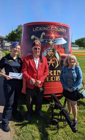 Mary Ann Township Fire Chief and Buckeye Lake Assistant Fire Chief Keisha Amspaugh (left) receives grant funding on behalf of both departments from Aladdin Shriners.