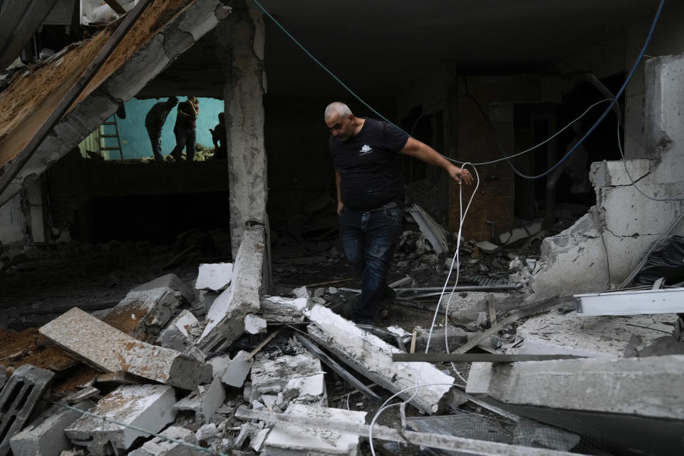 Palestinians inspect a damaged building following an Israeli army raid in Nour Shams refugee camp in the northern West Bank, Sunday, Sept. 24, 2022. Palestinians said at least two people were killed in the raid, which the army said was carried out to destroy a militant command center and bomb-storage facility in the building. (AP Photo/Majdi Mohammed)