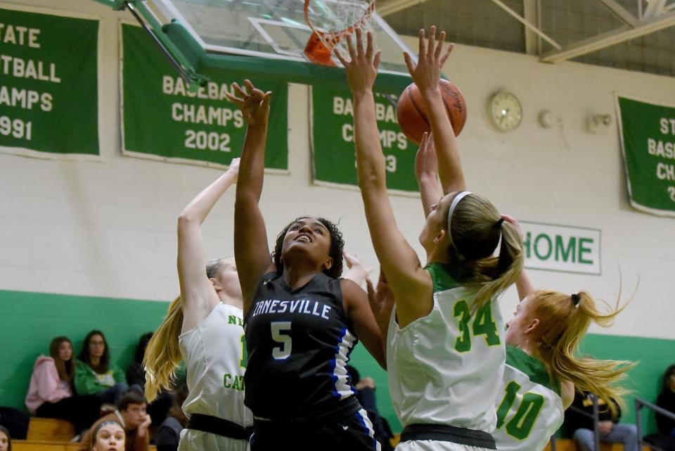 Zanesville sophomore Jersey Draughn loses possession going up for a shot against defense from Newark Catholic seniors Chloe Peloquin (34) and Brooklyn Smith (10). The Green Wave defeated the visiting Lady Devils 40-36 on Wednesday, Jan. 26, 2022.