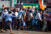 Military supporters use slingshots against pro-democracy protesters during a military support rally in Yangon