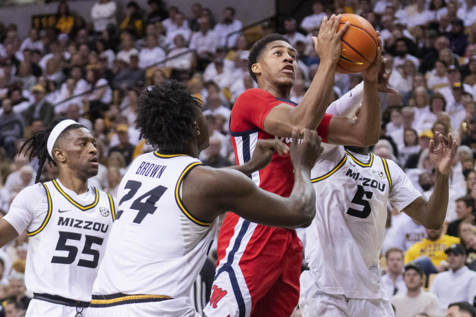 Mississippi's TJ Caldwell, top, shoots between Missouri's D'Moi Hodge, right, Sean East II, left, and Kobe Brown during the first half of an NCAA college basketball game Saturday, March 4, 2023, in Columbia, Mo. Missouri won 82-77. (AP Photo/L.G. Patterson)
