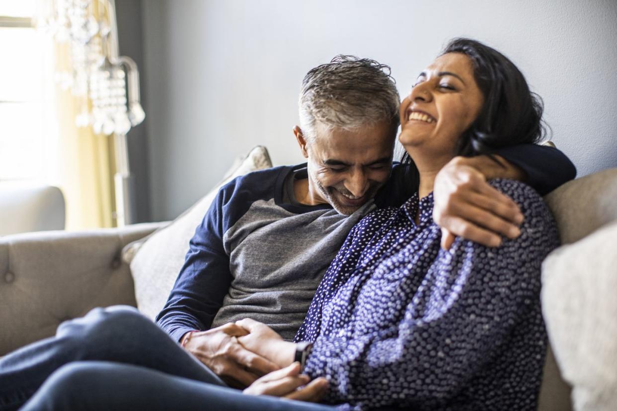 husband and wife embracing on couch