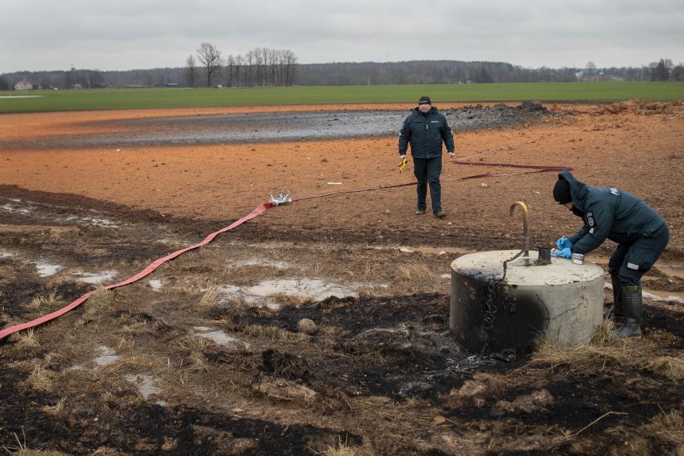 Employees work at the site of the damaged pipeline near Valakeliai village, outside Pasvalys, 175 km (109 miles) north of Vilnius in northern Lithuania on Saturday Jan. 14, 2023. A powerful gas pipeline explosion that prompted the evacuation of a village in northern Lithuania was most likely caused by a technical malfunction, the head of the country's natural gas transmission system said Saturday. The blast Friday evening sent flames 50 meters (about 150 feet) into the sky. (AP Photo/Mindaugas Kulbis)