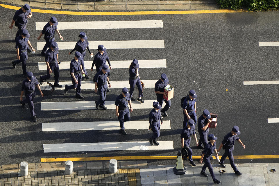 Security personnel march to their duty outside the Evergrande headquarters in Shenzhen, China, Friday, Sept. 24, 2021. Things appeared quiet at the headquarters of the heavily indebted Chinese real estate developer Evergrande, one day after the day it had promised to pay interest due to bondholders in China.(AP Photo/Ng Han Guan)