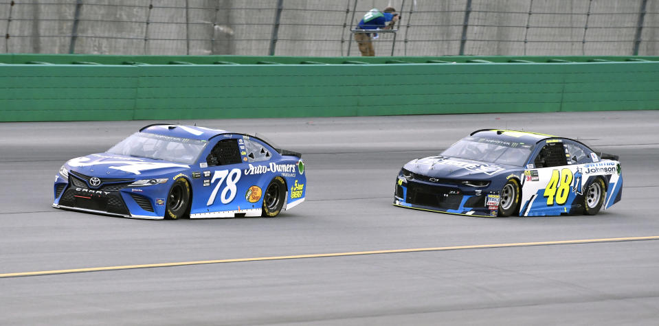 Martin Truex Jr. (78) leads Jimmie Johnson (48) into Turn 1 during the NASCAR Cup Series auto race at Kentucky Speedway, Saturday, July 14, 2018, in Sparta, Ky. (AP Photo/Timothy D. Easley)