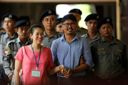 Detained Reuters journalist Wa Lone arrives with his wife Pan Ei Mon, escorted by police, before a court hearing in Yangon, Myanmar May 22, 2018. REUTERS/Ann Wang