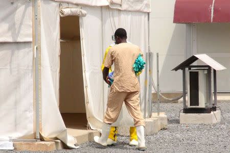 A health worker enters a tent in an Ebola virus treatment center in Conakry, Guinea, November 17, 2015. REUTERS/Saliou Samb