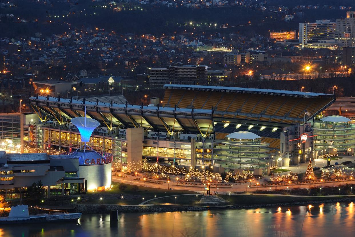 Pittsburgh Steelers, Acrisure Stadium, Pittsburgh, exterior of stadium during the holidays in the late evening, lights lit up and surrounding area, homes in the hills