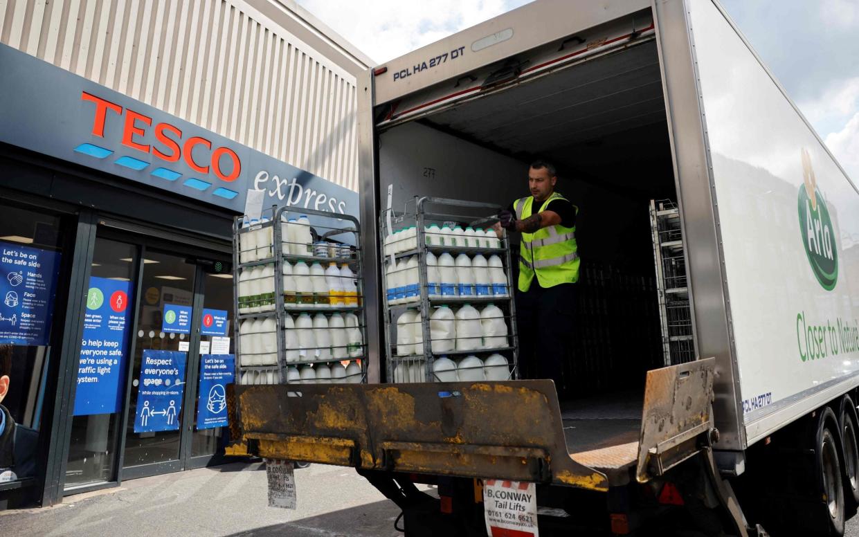 A lorry driver for Arla Foods makes a milk delivery to a Tesco in London, 2021