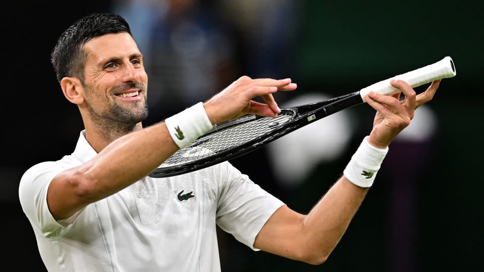 Djokovic pretends to play the violin for his daughter as he celebrates winning against Denmark's Holger Rune. - Andrej Isakovic/AFP/Getty Images