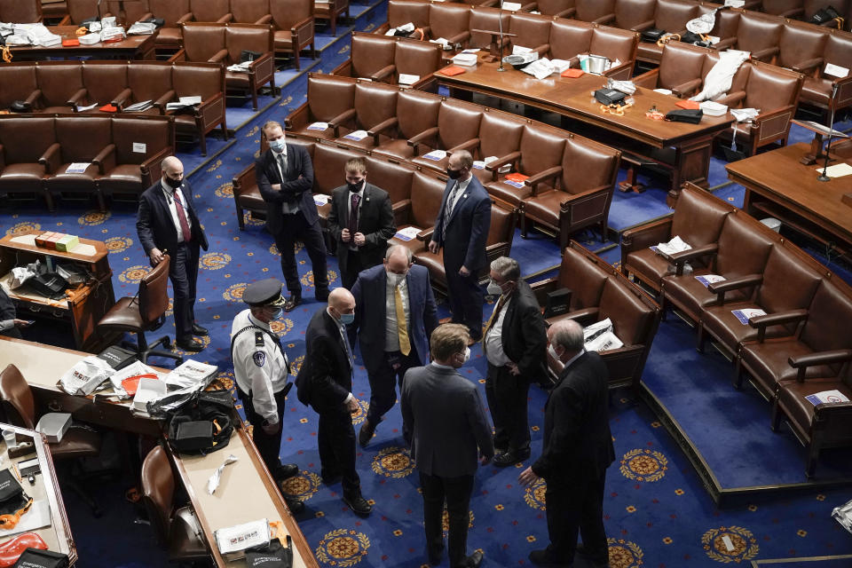 FILE - U.S. Capitol Police officials meet on the floor of the House Chamber after rioters tried to break into the chamber at the Capitol in Washington, Wednesday, Jan. 6, 2021. (AP Photo/J. Scott Applewhite, File)