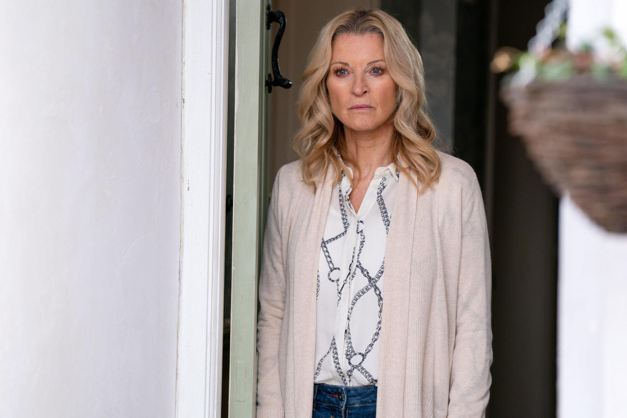  Kathy Beale standing at her front door looking sad in EastEnders. 