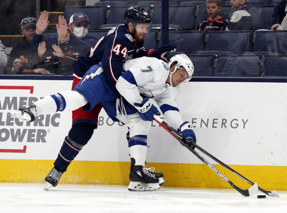 Columbus Blue Jackets defenseman Vladislav Gavrikov, left, grabs Tampa Bay Lightning forward Mathieu Joseph during the second period of an NHL hockey game in Columbus, Ohio, Thursday, April 8, 2021. (AP Photo/Paul Vernon)