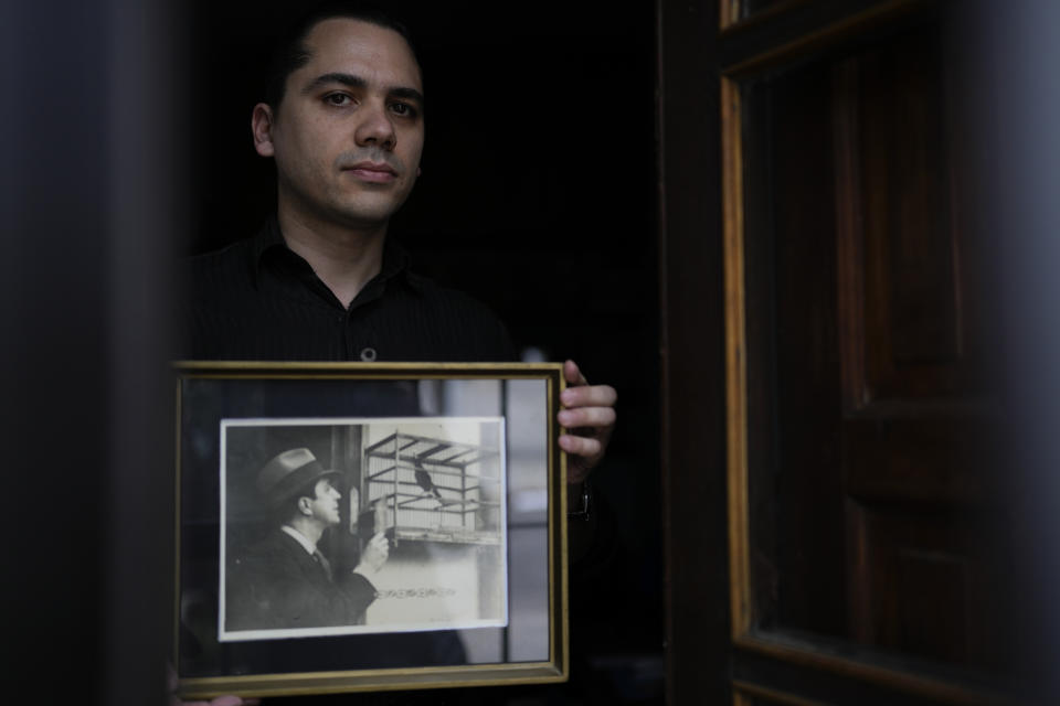 Andrés Parrado poses for a photo with a framed picture of Argentine tango singer Carlos Gardel in Montevideo, Uruguay, Saturday, July 22, 2023. “He was like the Jesus of my childhood,” said Parrado, an architect and tango dancer, who wears slicked back hair like his idol and praises his discipline, generosity and resilience. “I venerate him as an ideal of an artist and a human being.” Parrado identifies himself as agnostic and is part of the growing ranks of the religiously unaffiliated in Uruguay.